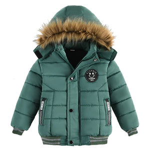 Green children's puffer jacket with fur-lined hood on a white background