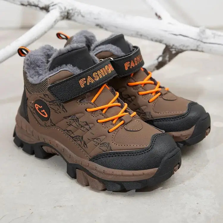 Brown children's boots with orange laces on a light background