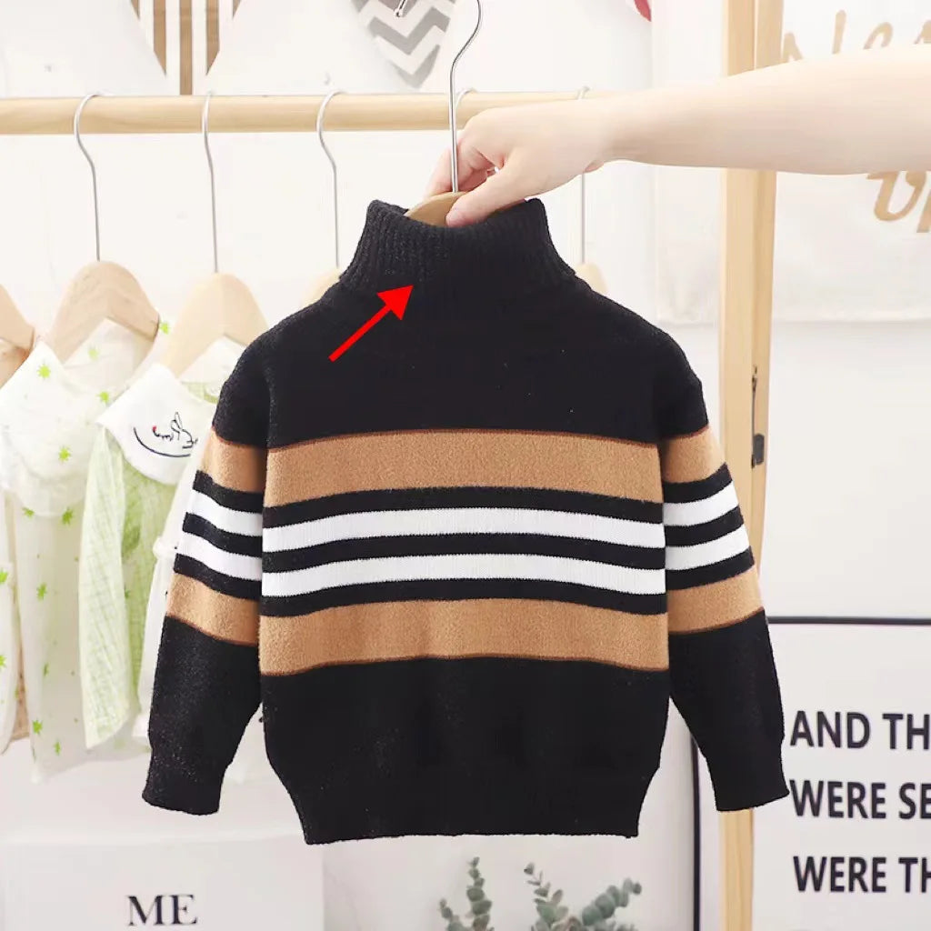 Children's striped sweater with a red arrow pointing to a small detail, hanging on a rack.