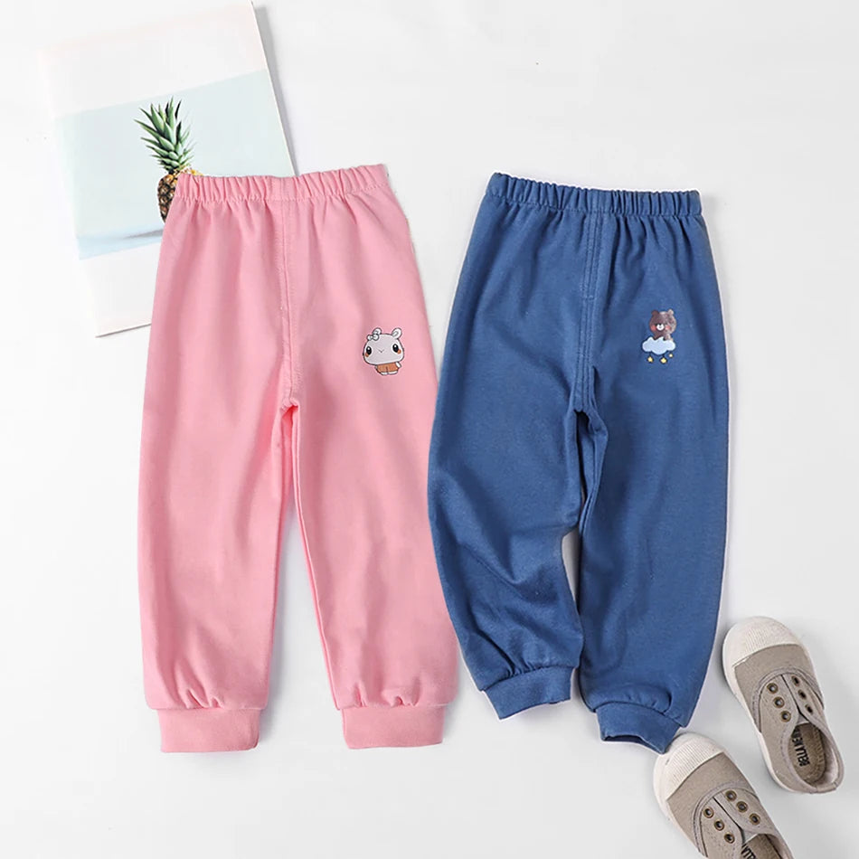 Pink and blue children's sweatpants with cartoon designs on a white background.