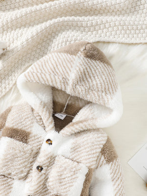 Close-up of a textured beige and brown garment with a tag on a light background