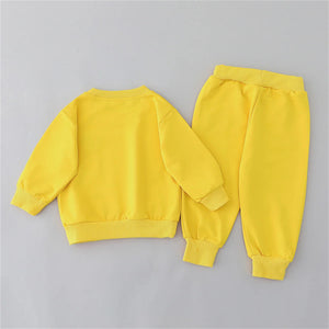 Yellow children's sweatshirt and pants set on a gray background